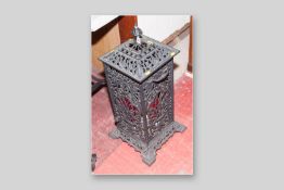 A reproduction cast iron pierced floor standing lamp with spare red glass panels, embossed to the