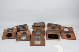 A collection of fifty plus Magic Lantern slides in wooden frames including three mechanical
