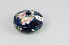 A Moorcroft pottery cobalt ground dish and cover decorated with floral pattern, 4.75 ins (12 cms)