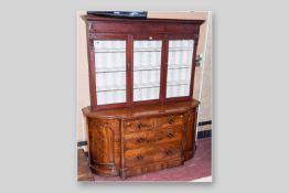 A Victorian mahogany sideboard base with curved side doors, a central bank of two short and two long