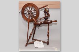 A 19th Century wooden Saxony spinning wheel with bone finial tips, 35 x 30 ins (89 x 76 cms), (