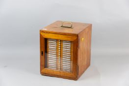 A pine single glazed door collector's cabinet with brass carrying handle, the door opening to reveal