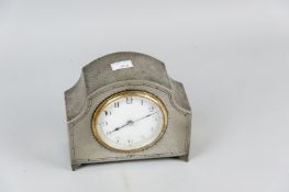 A beaten pewter mantel clock on corner bracket feet with French brass movement and white enamel