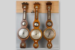Three Victorian banjo barometers with thermometers, all with swan neck pediments, one marked '