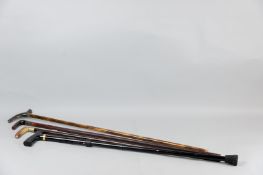 Four walking sticks of various compositions, three with horn handles, one with hallmarked silver
