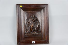 An oak framed chamfered carved panel depicting a couple in period costume on a rocky outcrop, 17 x