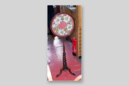 A Victorian rosewood pole screen having a twist column base on three splayed legs, circular rosewood