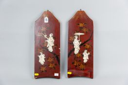 A pair of Japanese hanging red lacquer work panels, floral decorated with gilt highlighting, both
