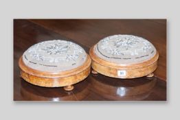 A pair of circular Victorian walnut footstools with beadwork pads, 11 ins (28 cms) diameter