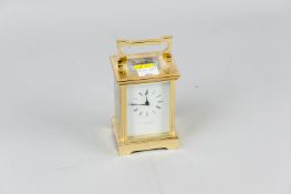 A 20th Century brass carriage clock, the faceted glass rear door and sides showing a striking bell