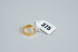 A twenty two carat beaten gold wide wedding band, 5.4 grms