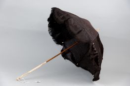 A 19th Century lady's parasol with carved ivory handle and top, the embossed dark coloured canopy