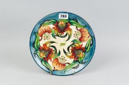 A Moorcroft pottery limited edition (608/750) year plate for 1999, decorated in the 'Tiger Lily'