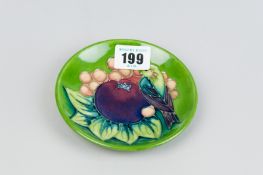 A Moorcroft pottery dish decorated in the 'Finch' pattern on a green ground, 'Moorcroft' and 'Made