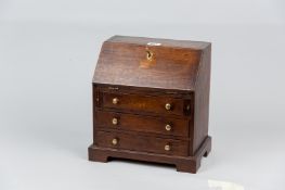 An apprentice piece oak fall front bureau with twin loafers and three drawers on a bracket plinth