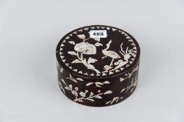 An early 20th Century Oriental papier mache circular lidded box, inlaid with mother of pearl
