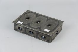 A pewter covered sandalwood box with stylized decoration and black, possibly pottery cabouchon