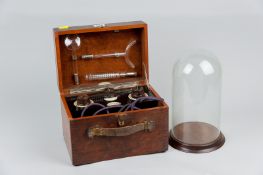 A mahogany cased Rogers electric medical vitalator and a glass dome on a turned wood stand