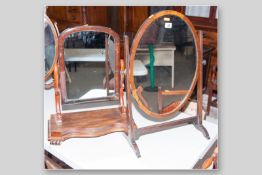 A Regency mahogany oval swing toilet mirror, 26 x 18 ins (66 x 45.5 cms) and a Victorian mahogany