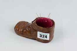 An Edwardian carved child's shoe pin cushion