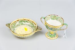 A Wedgwood lustre twin handled cup on pedestal base, yellow ground with interior and exterior