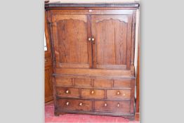A late 18th/early 19th Century press cupboard, the moulded cornice over a crossbanded frieze, double