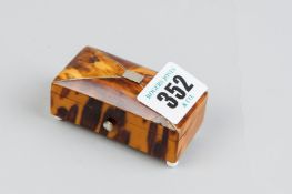 An oblong silver mounted tortoiseshell patch box with slightly domed lid on corner porcelain