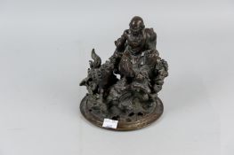 A well cast Oriental bronze censor cover depicting an Oriental God seated on a rocky outcrop with