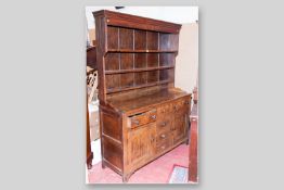 An antique oak and pine flat fronted Welsh dresser with three shelf Delft rack above, a good