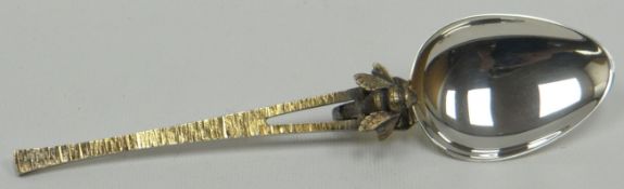 An Elizabeth II silver honey-spoon having a textured parcel-gilt handle and with applied honey-
