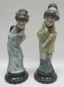 A pair of Lladro standing geisha on circular bases, 11.5ins high (29cms)