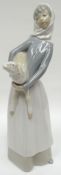 A Lladro figure of a farm-girl holding lamb in her arms, 11ins high (28cms)
