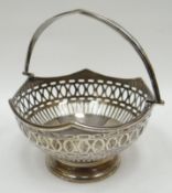 A pierce-work silver basket on circular foot with wavy rim and swing-handle, Birmingham 1928, 3.