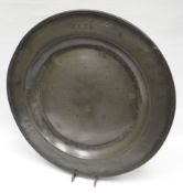 An early possibly South West of England pewter charger of plain dish form with broad rim, the rim