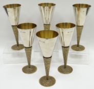 A set of six Elizabeth II silver goblets raised upon gilded and textured stems and with spreading