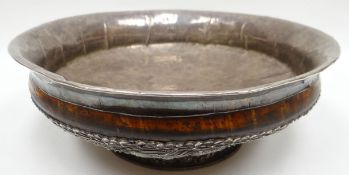 A Tibetan burr-wood bowl, the foot and base lined with profusely decorated silver with embossed