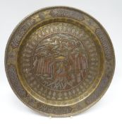 An Islamic brass dish, probably Cairo-ware, inlaid with copper and white metal, being decorated with