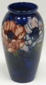 A Walter Moorcroft blue-ground tube-lined floral baluster vase with narrow neck, 7.5ins high (