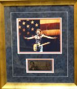 An authenticated signed photograph of musician Bruce Springsteen performing on stage, presented