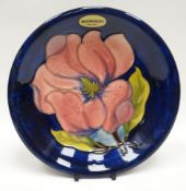 A Walter Moorcroft blue-ground tube-lined floral dish, 7.5ins diam (19cms)