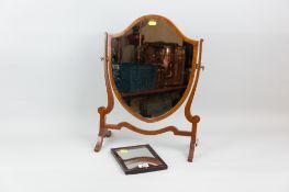 An Edwardian mahogany and string inlaid shield-shaped toilet mirror on stand, 48 x 38 cms, and a
