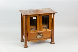 An oak smoker's cabinet having a pair of upper opening drawers with fall front drawer below and with