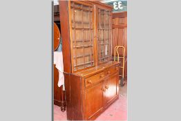 A large 19th Century oak bookcase cupboard, the upper section having twin glazed doors each with six