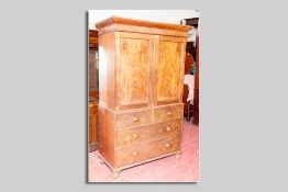 An early Victorian mahogany press cupboard, the upper section having twin doors revealing sliding