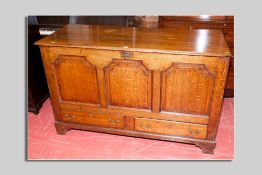 An early 19th Century oak mule chest having a twin plank moulded edge top over three fielded