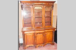 A Victorian mahogany three door bookcase, three glazed top doors below a shaped cornice with three