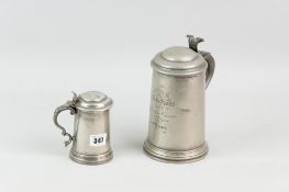 Two pewter glass bottomed lidded tankards, the larger with starburst cut ruby red glass bottom,