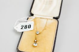 A 9ct gold fine link neck chain with a drop pendant having two aquamarines, one round cut, one