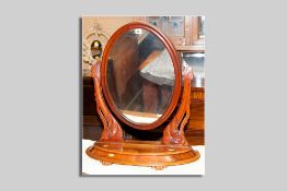 A Victorian mahogany swing toilet mirror having a bow front lidded base