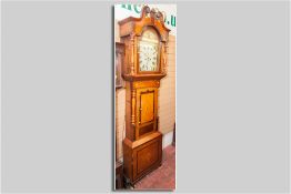 A Victorian oak and mahogany longcase clock with 14 ins painted arched top dial, Roman numerals with